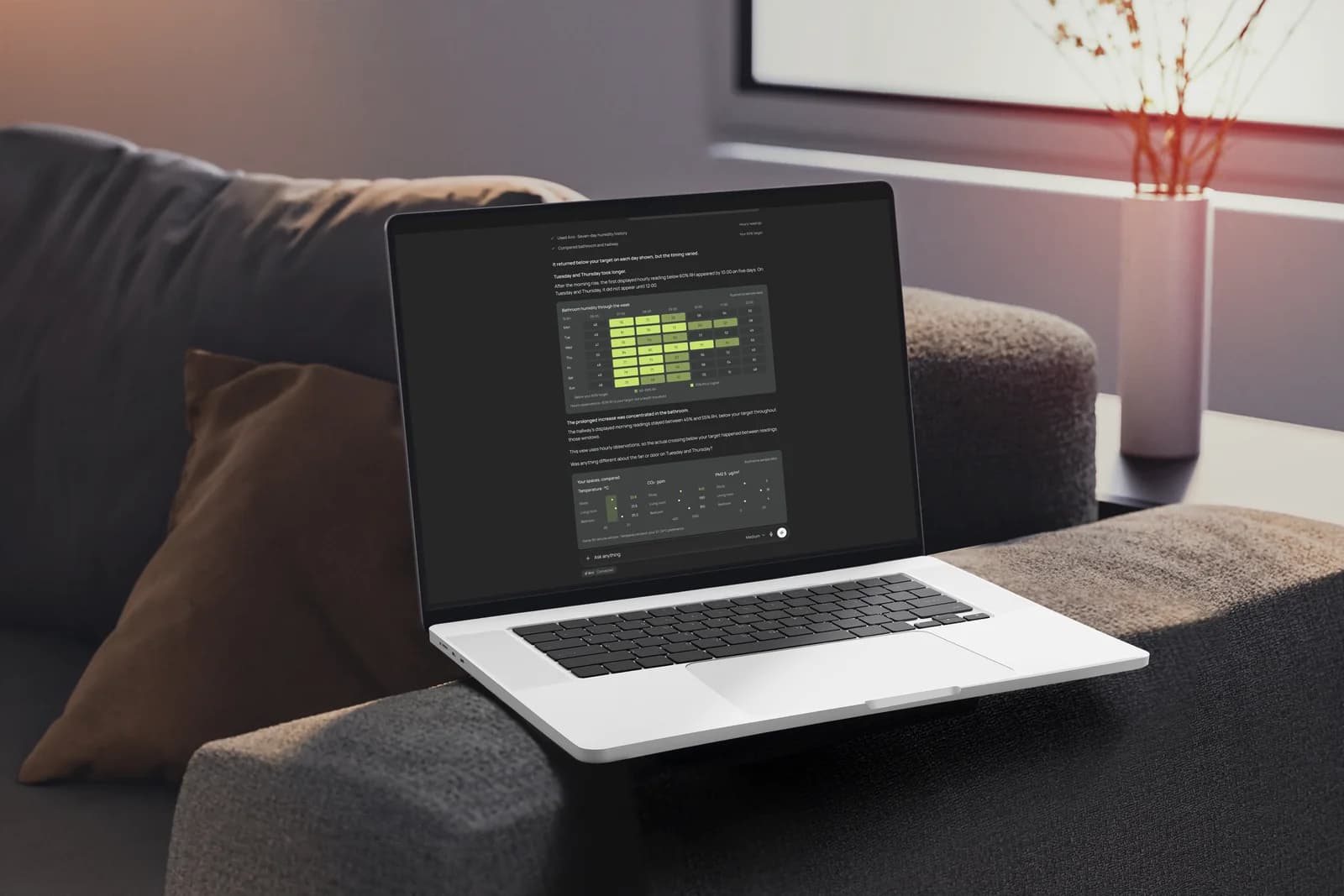 A MacBook on a sofa showing an AI response with environmental data charts